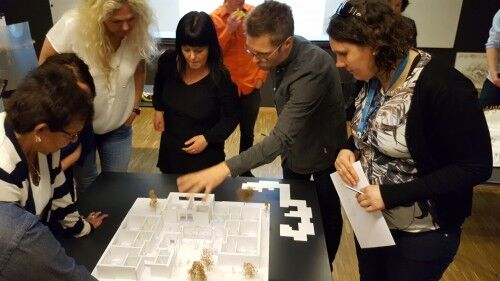 Arkitekter og representanter fra Kristiansand Kommune diskuterer modeller av skissene de har. Foto: Ilse van Lingen.