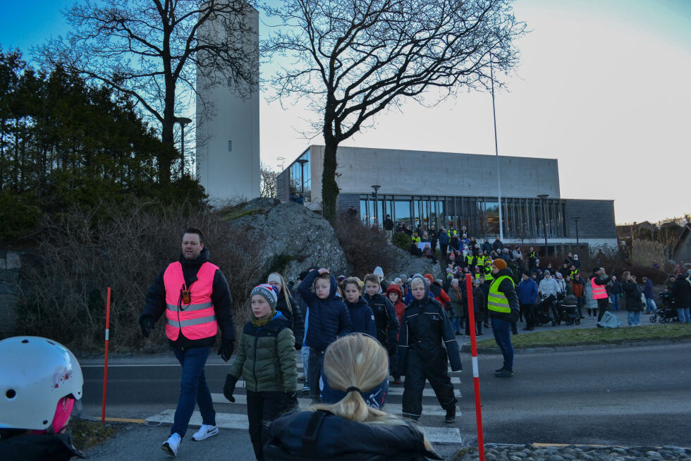 Skoleelever som blir fulgt over veien til busstoppene de må eventuelt ta til Møvig skole.
 Foto: Leah Kittelsen