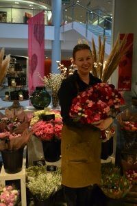 Anne-Cecilie Drangsholt-Berntsen holder opp en av butikkens blomsterbuketter.