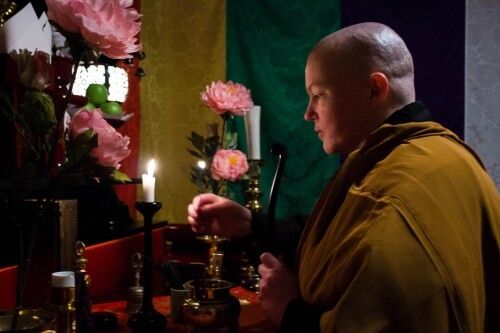 Den kvinnelige buddhistpresten, Anjun Reiman, som tenner røkelse under en kveldsmesse. Foto: Helene Eriksen