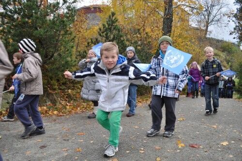 Hans Lossius (8) vifter med FN-flagget sammen med de andre barna i 3A på Sjøstrand skole. (Foto: Linn Johansen)