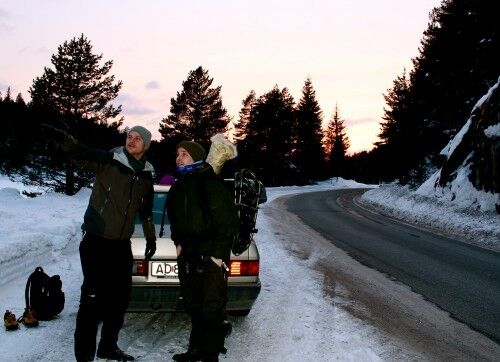 Kjell-Erik Mathiassen og Christoffer peker ut kursen med en rødlig solnedgang i bakgrunnen.