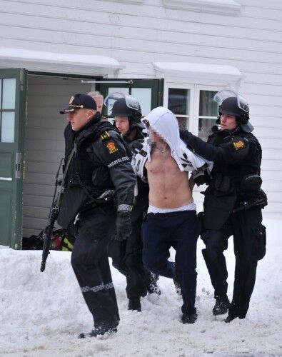 En av de mistenkte føres ut av politistyrker. FOTO: Hanne Kristin Pedersen