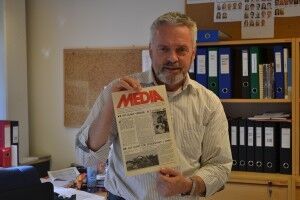 Administrasjonssjef på Mediehøgskolen Gimlekollen Ingar Hjelset viser fram det første nummeret av informasjonsbladet Media fra 1981, som i dag heter M-link. Foto: Olav Andreas Hoel.