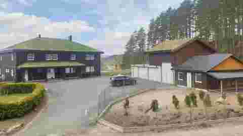 Innkjørselen til ekteparet. Her ser vi huset, garasjen fjøset og innhegningen til noen av dyrene. Foto: Thale Holm